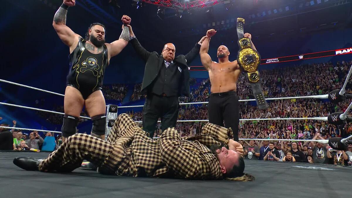 The Vision standing over Seth Rollins on WWE Raw